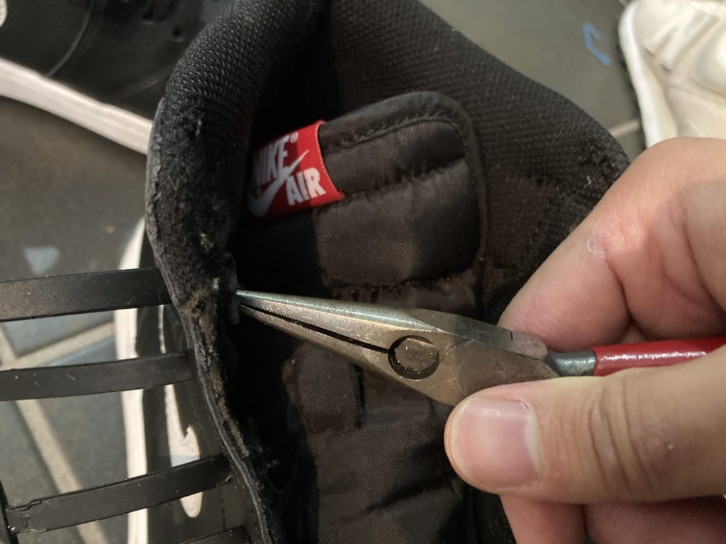 結ばない靴紐の先端部をペンチで引っ張る